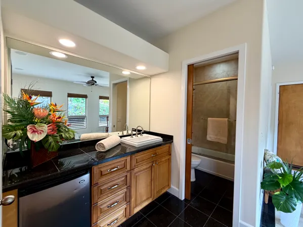 a spacious bathroom with a granite countertop sink a large mirror and a shower