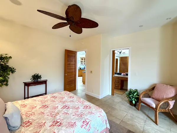 a bedroom with a bed chandelier and a chair