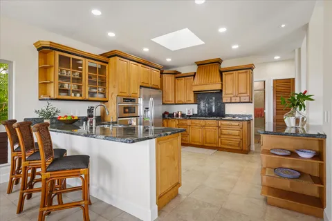 a kitchen with stainless steel appliances kitchen island granite countertop a stove a sink and a refrigerator