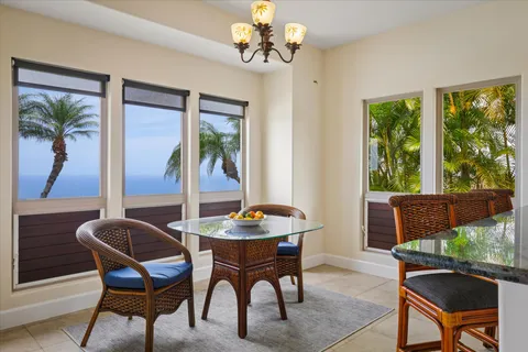 a dining room with furniture a large window and a chandelier