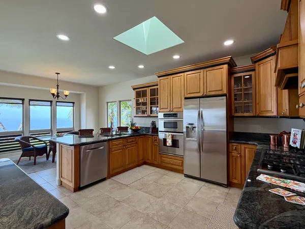 a kitchen with stainless steel appliances granite countertop a stove refrigerator and cabinets