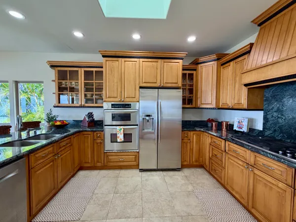 a kitchen with stainless steel appliances granite countertop a refrigerator and a sink