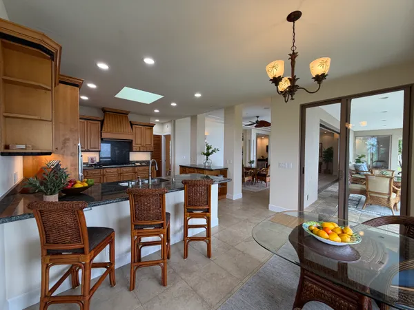 a view of a dining room and a kitchen with furniture and chandelier