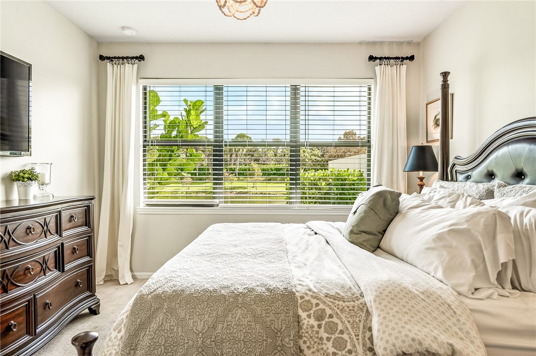 5191 Unity Square Vero Beach, FL 32967 - Photo 20 of 36 a bedroom with a bed a dresser and a large window