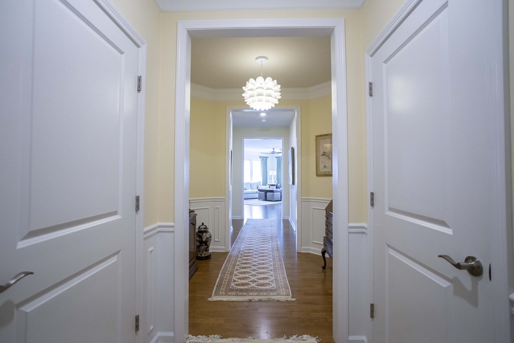 10 Abigail Way, Unit 3004 Reading, MA 01867 - Photo 2 of 32 a view of a hallway with wooden floor and a dining room
