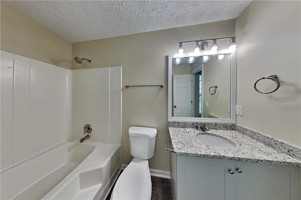 1049 Braddock Circle Woodstock, GA 30189 - Photo 11 of 20 a bathroom with a granite countertop sink and a mirror