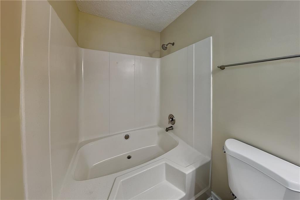 1049 Braddock Circle Woodstock, GA 30189 - Photo 12 of 20 a bathroom with a tub shower and toilet