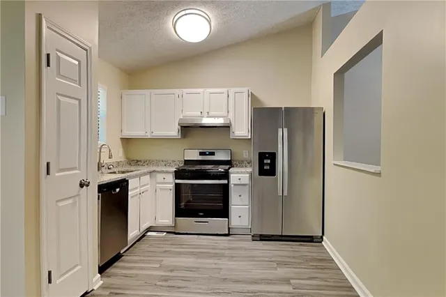 a kitchen with a refrigerator stove and sink