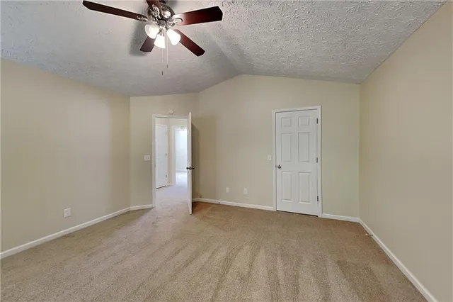 a view of an empty room and chandelier fan
