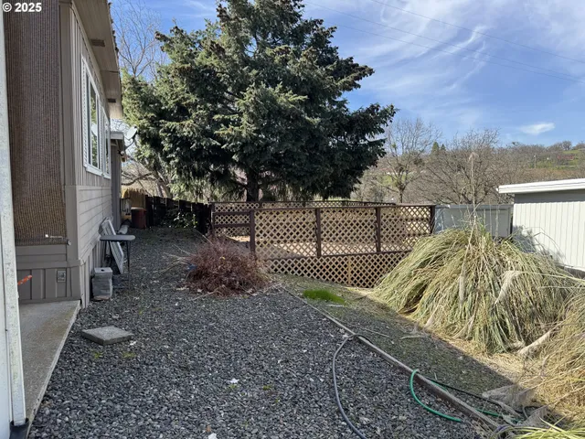 a view of a yard with wooden fence