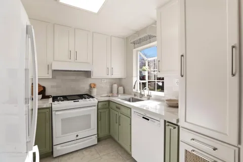 a kitchen with white cabinets and white appliances