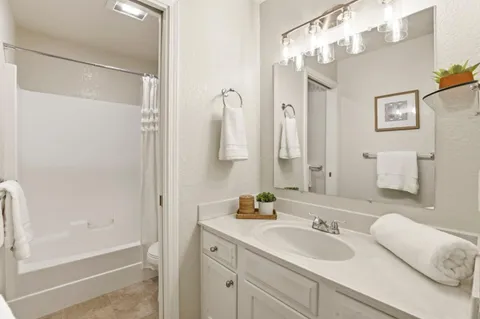 a bathroom with a double vanity sink mirror and shower
