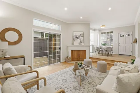 a living room with furniture a fireplace and a floor to ceiling window