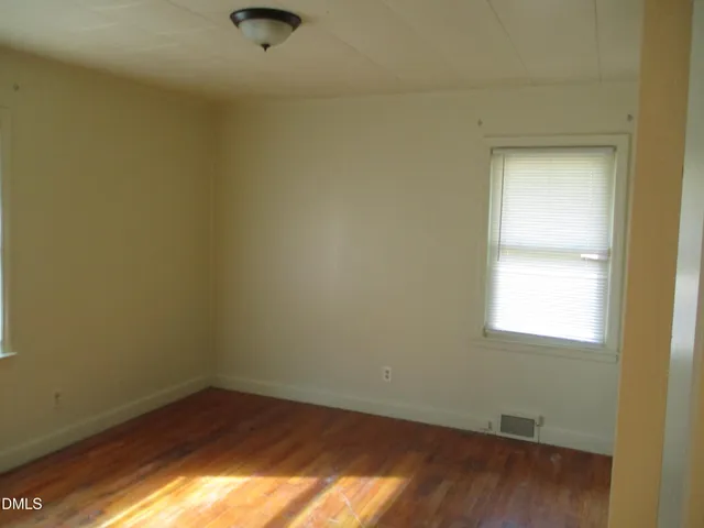 a view of a small space with wooden floor and a window