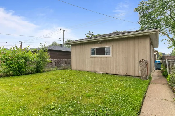 a view of backyard of house with green space