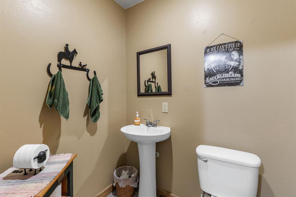 13315 Highway 281 Scotland, TX 76379 - Photo 12 of 40 Pedestal sink with chrome faucet, framed mirror