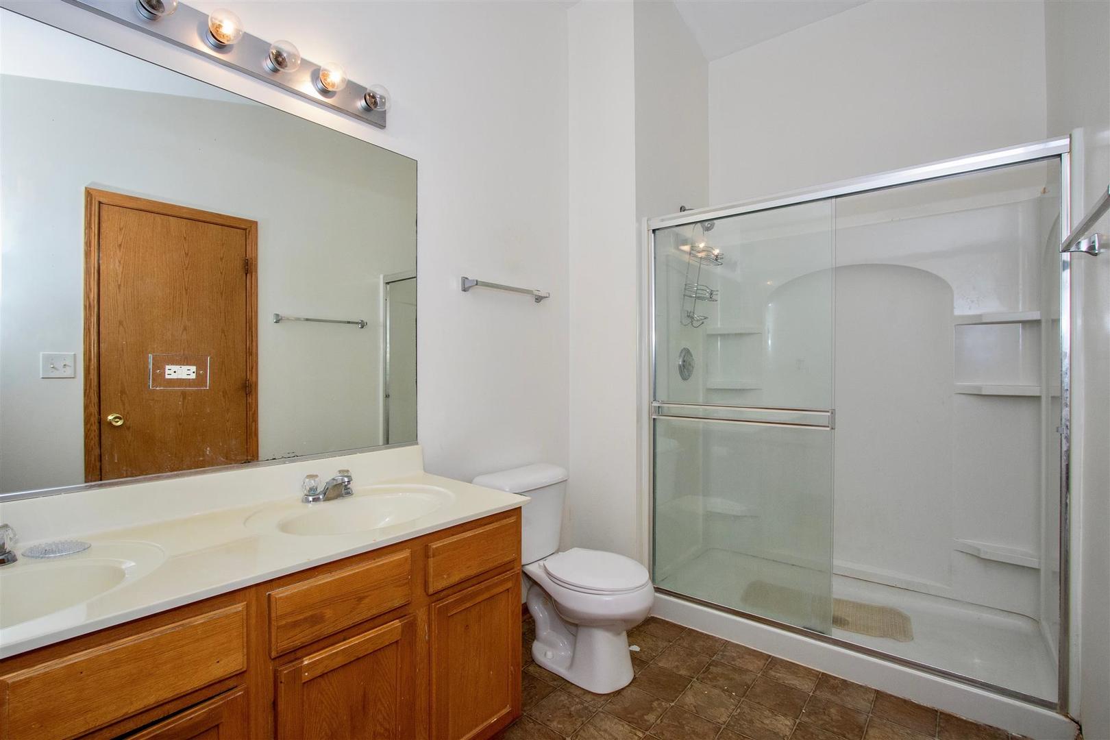 175 Springbrook Trail South Oswego, IL 60543 - Photo 11 of 25 a bathroom with a shower sink vanity and toilet
