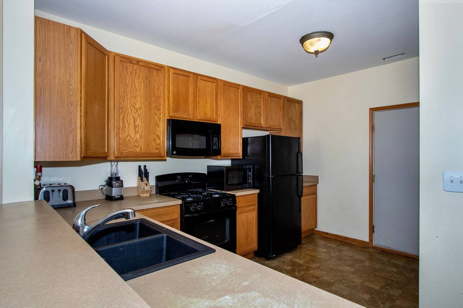 175 Springbrook Trail South Oswego, IL 60543 - Photo 3 of 25 a kitchen with a sink a stove and a microwave