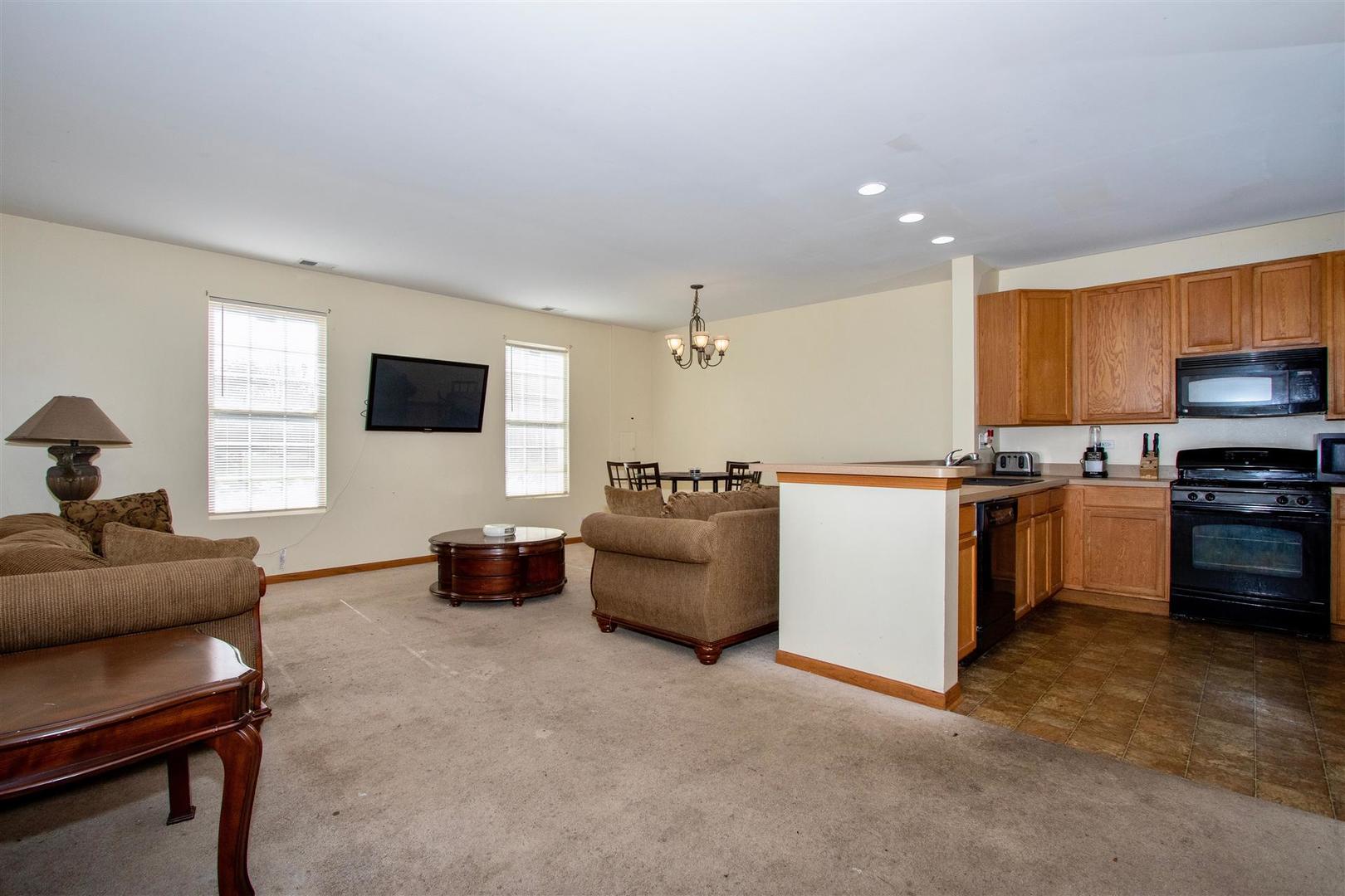 175 Springbrook Trail South Oswego, IL 60543 - Photo 4 of 25 a living room with furniture and a flat screen tv