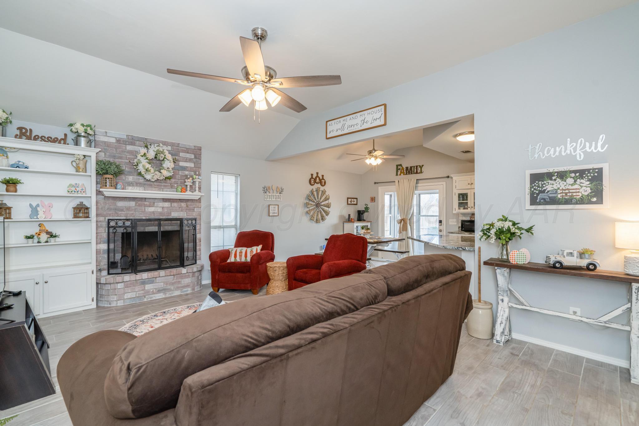 2205 Troveta Drive Amarillo, TX 79110 - Photo 11 of 28 a living room with furniture a fireplace and a chandelier
