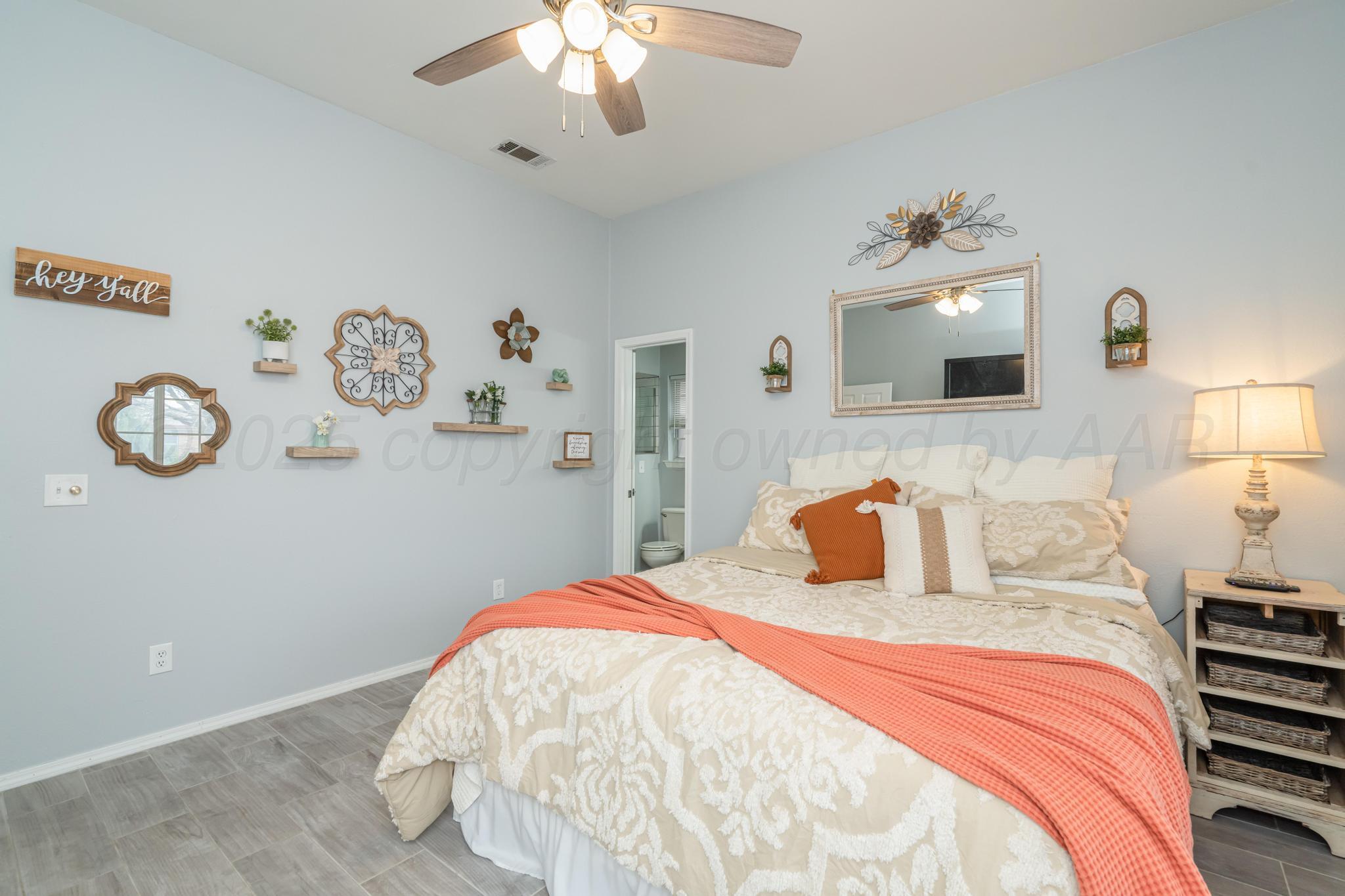 2205 Troveta Drive Amarillo, TX 79110 - Photo 12 of 28 a bedroom with a bed and a chandelier