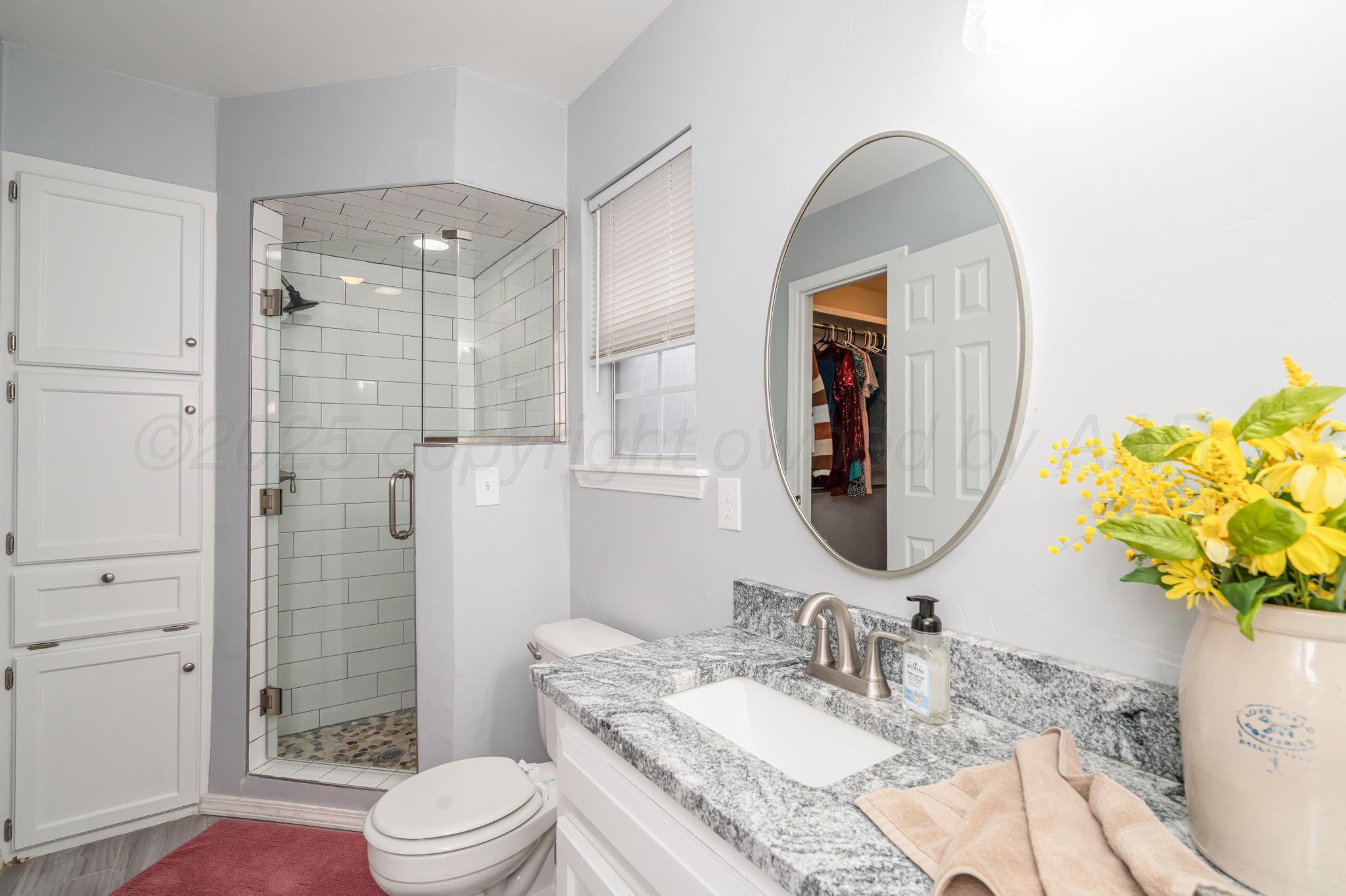2205 Troveta Drive Amarillo, TX 79110 - Photo 14 of 28 a bathroom with a granite countertop sink mirror toilet and shower