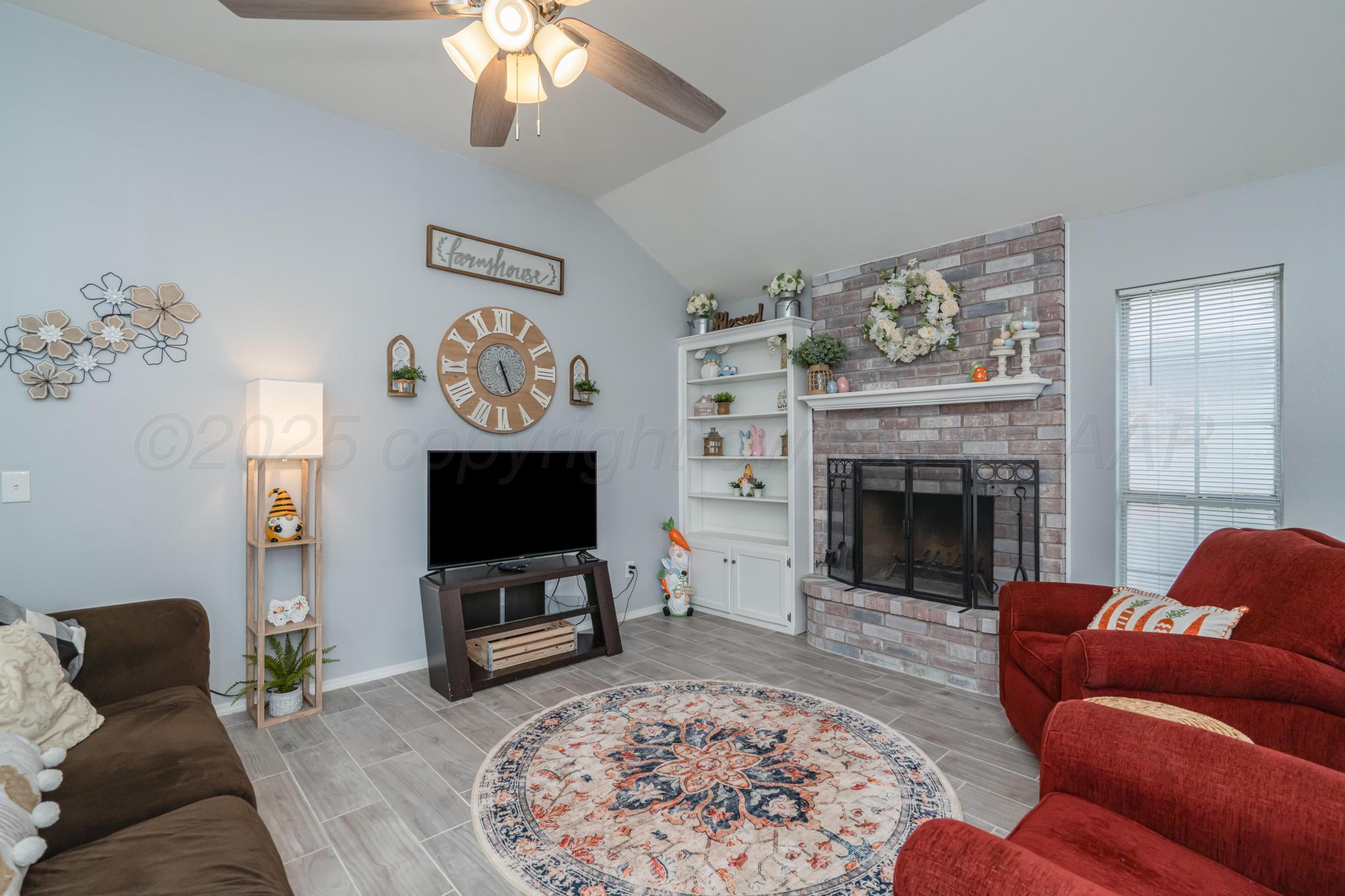 2205 Troveta Drive Amarillo, TX 79110 - Photo 2 of 28 a living room with furniture a flat screen tv and a fireplace