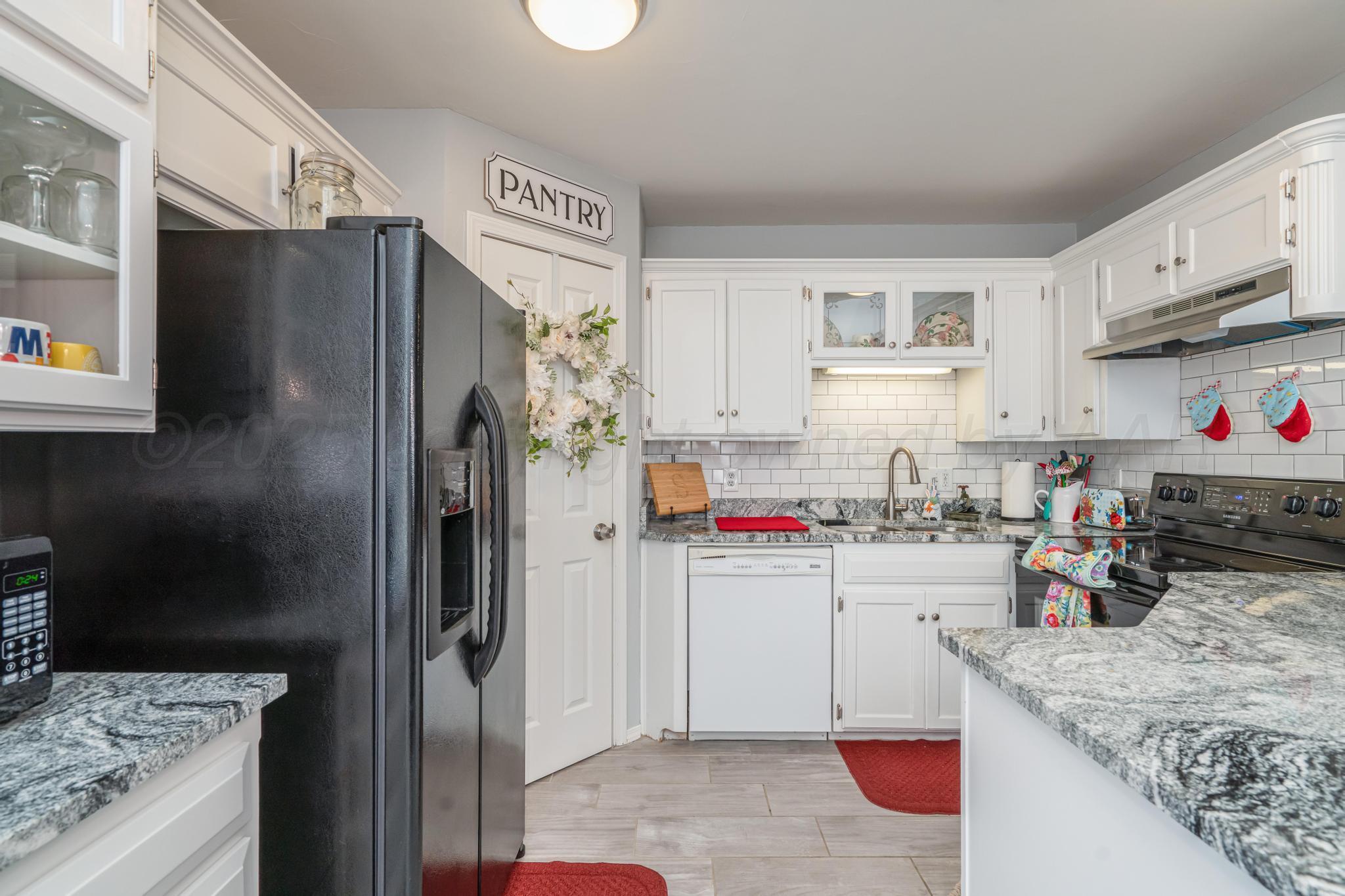 2205 Troveta Drive Amarillo, TX 79110 - Photo 7 of 28 a kitchen with refrigerator and cabinets