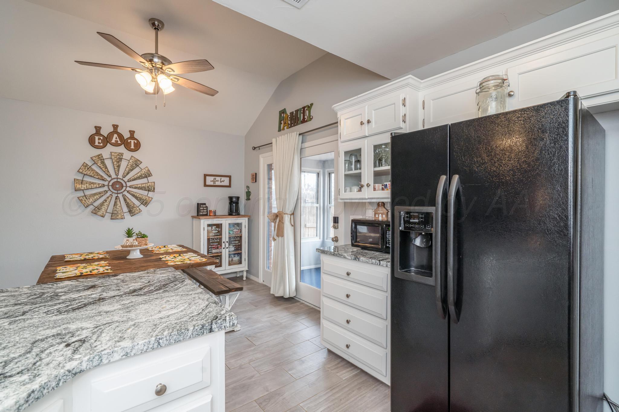 2205 Troveta Drive Amarillo, TX 79110 - Photo 8 of 28 a kitchen with stainless steel appliances kitchen island granite countertop a refrigerator a stove and a sink