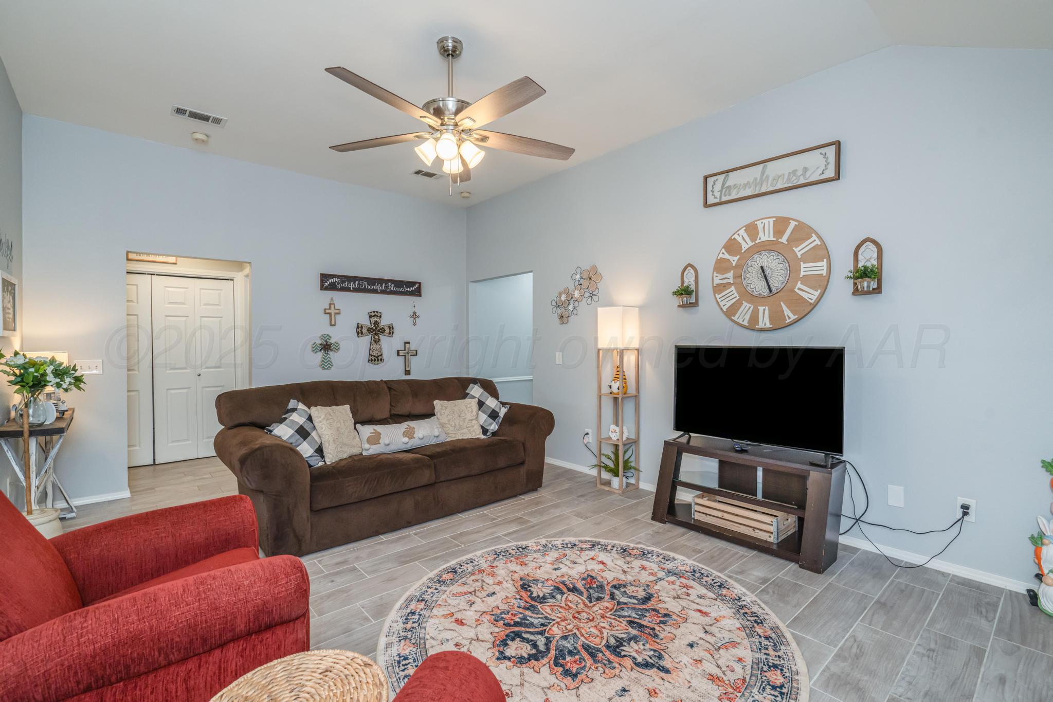 2205 Troveta Drive Amarillo, TX 79110 - Photo 10 of 28 a living room with furniture a flat screen tv and a chandelier