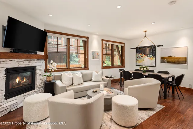 a living room with furniture a flat screen tv and a fireplace