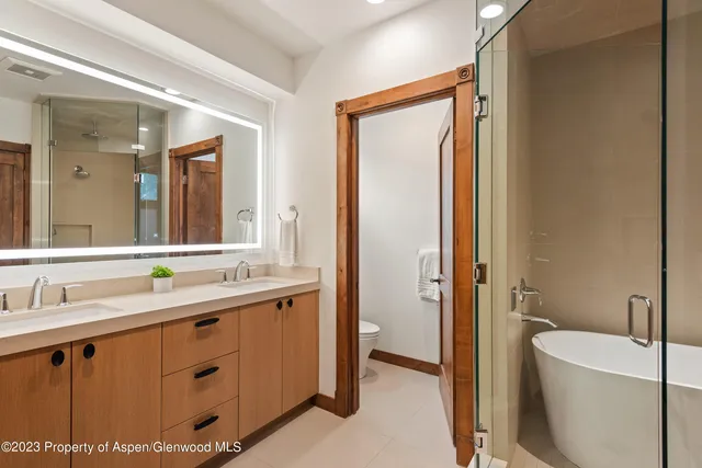 a bathroom with a double vanity sink mirror and bathtub