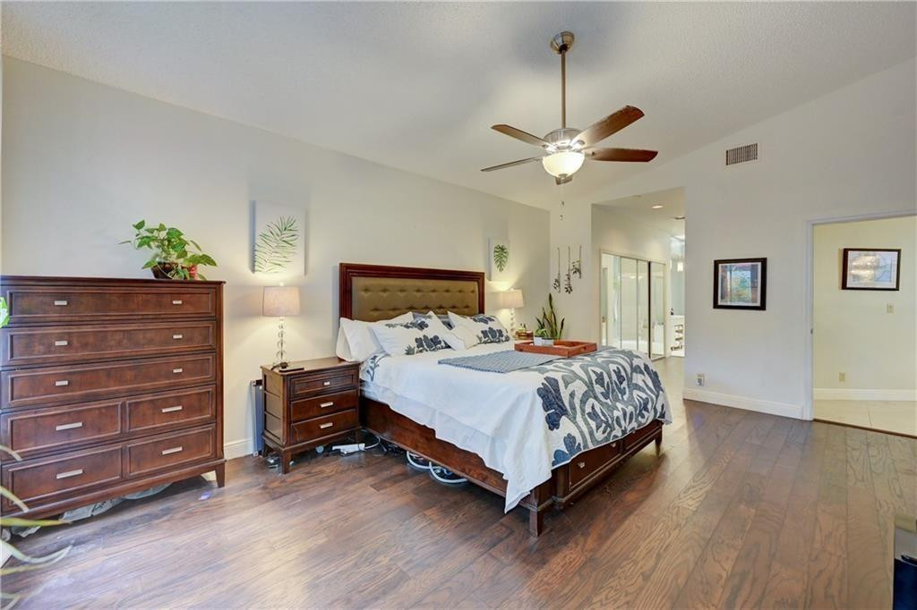 8171 Hampton Wood Drive Boca Raton, FL 33433 - Photo 15 of 56 a bedroom with a bed and a chandelier