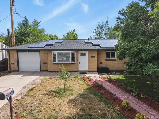 a front view of a house with a garden and yard