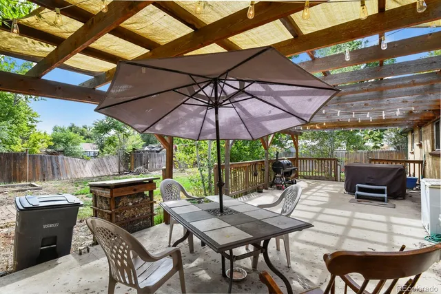 a view of a patio with table and chairs under an umbrella