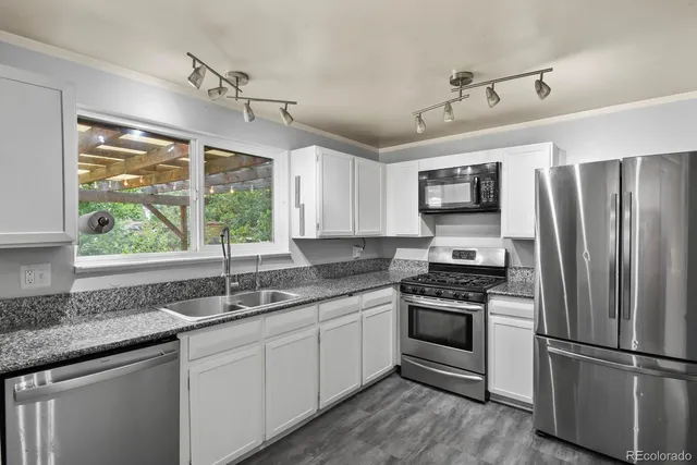 a kitchen with kitchen island granite countertop a sink stainless steel appliances and window