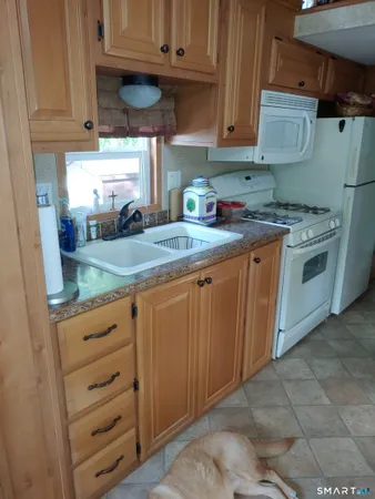 a kitchen with granite countertop a sink cabinets and stainless steel appliances