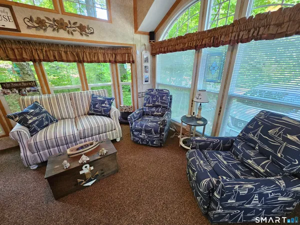 a living room with furniture fireplace and large windows