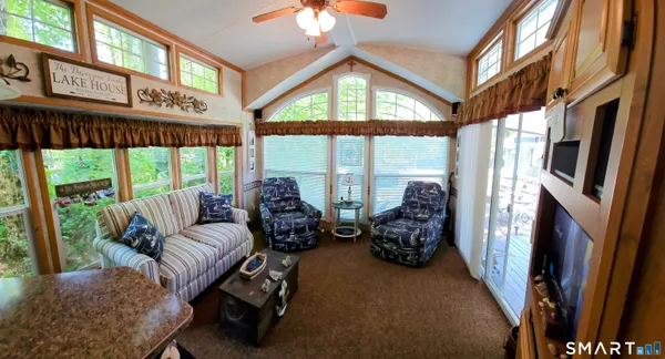 a living room with furniture fireplace and large windows