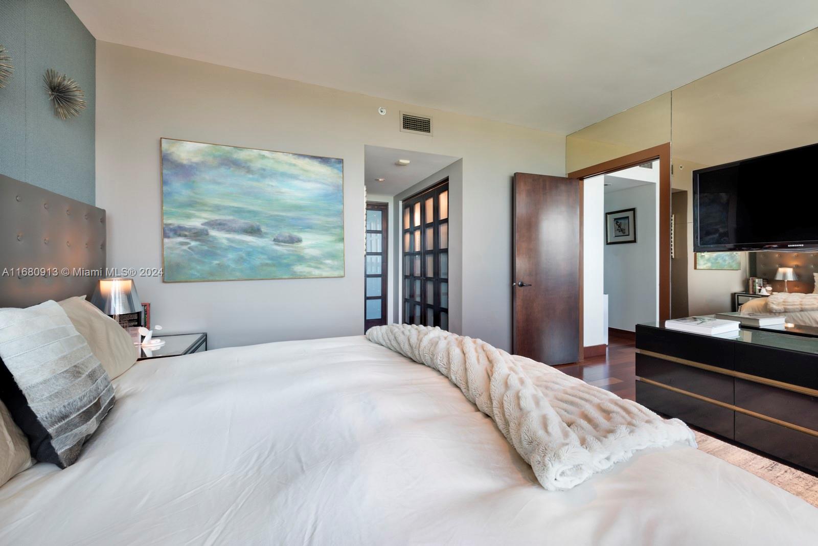 101 20th Street, Unit 2603 Miami Beach, FL 33139 - Photo 8 of 16 a bedroom with a large bed and a flat tv screen on a dresser