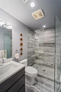 a bathroom with a sink a toilet and shower