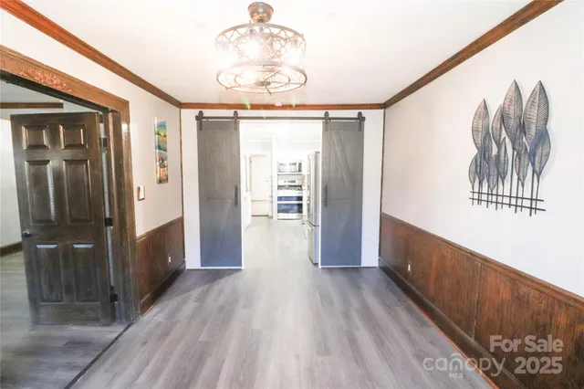 a view of a hallway with wooden floor and staircase