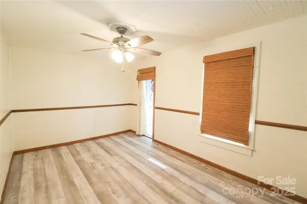 a view of a big room with wooden floor and windows