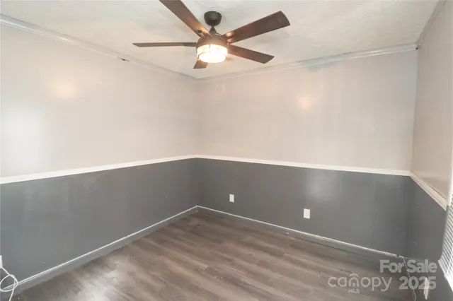 en empty room with wooden floor and fan