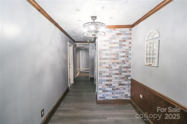 a view of a hallway with windows and chandelier