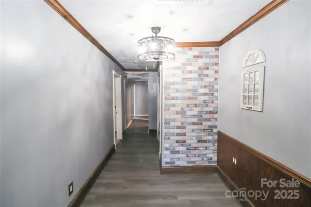 a view of a hallway with windows and chandelier
