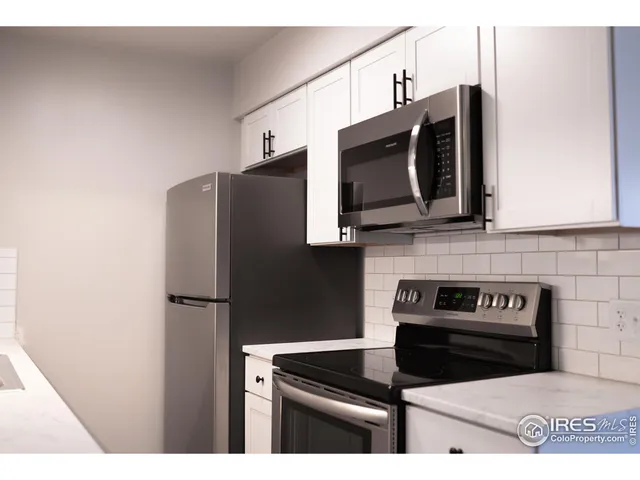a kitchen with stainless steel appliances a stove microwave and refrigerator