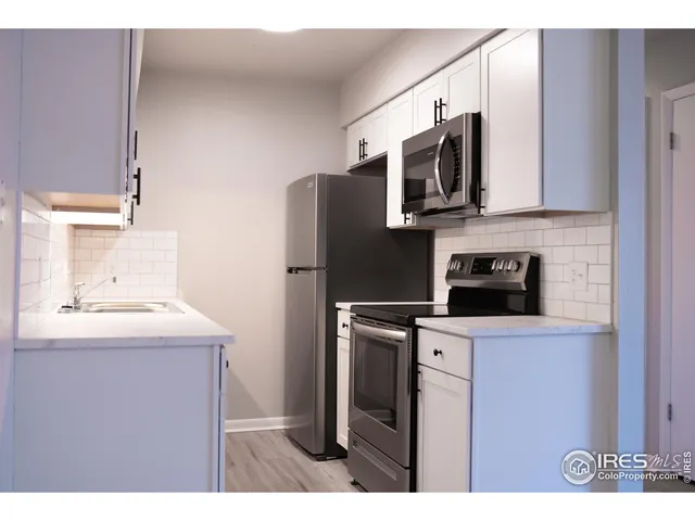 a kitchen with stainless steel appliances a microwave a sink and refrigerator