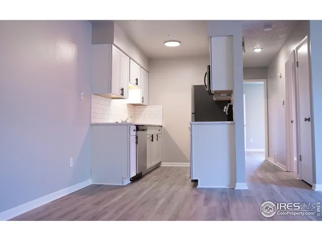 a open kitchen with a sink and wooden floor