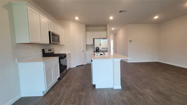 a kitchen with kitchen island white cabinets and stainless steel appliances